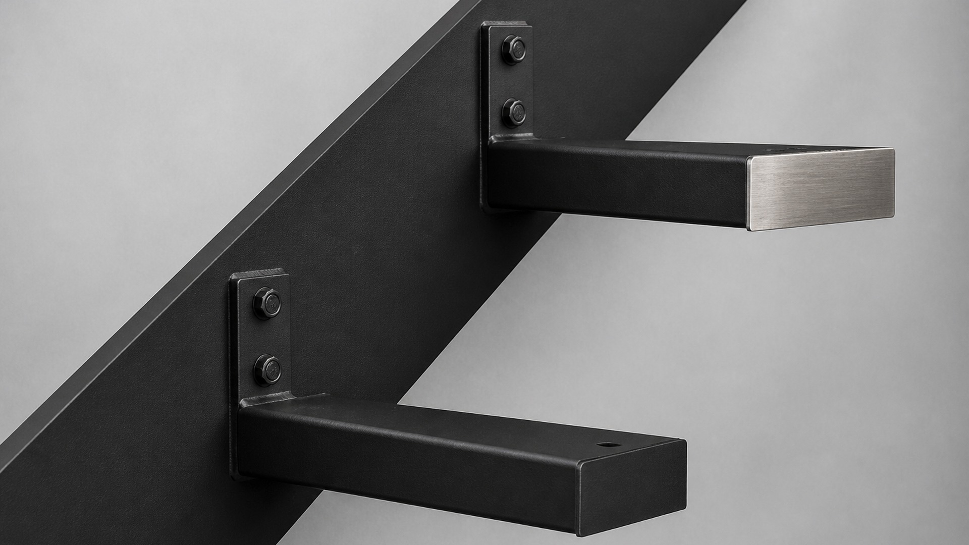 Black powder-coated tread supports bolted to a steel stringer, one with a brushed metal end.
